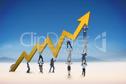 Composite image of business team holding up arrow