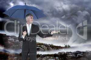 Composite image of happy businessman holding umbrella