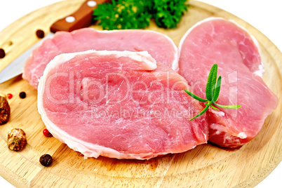 Meat pork slices with rosemary on round board