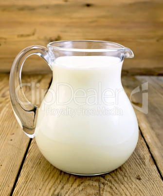 Milk in glass jug on board