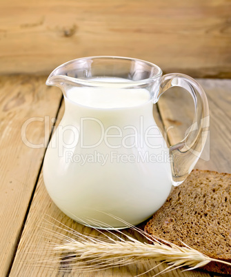 Milk in glass jug with bread on board
