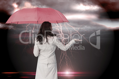 Composite image of businesswoman holding umbrella