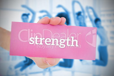 Woman holding pink card saying strength
