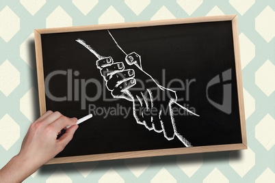 Composite image of hand drawing handshake with chalk