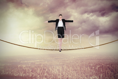 Composite image of businesswoman performing a balancing act