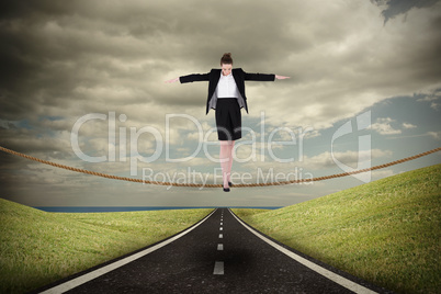 Composite image of businesswoman performing a balancing act