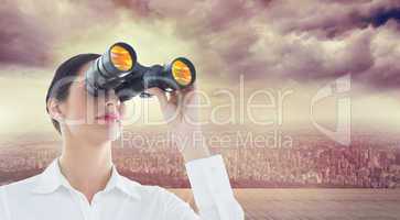 Composite image of business woman looking through binoculars