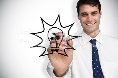 Composite image of businessman drawing light bulb