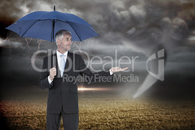 Composite image of happy businessman holding umbrella Composite image of happy businessman holding umbrella