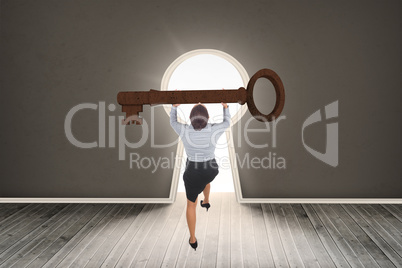 Composite image of businesswoman carrying large key