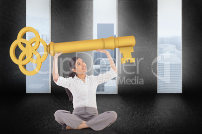 Composite image of businesswoman sitting cross legged carrying l