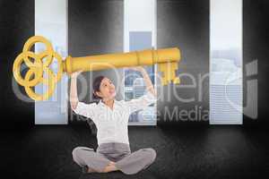 Composite image of businesswoman sitting cross legged carrying l