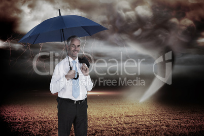 Composite image of happy businessman holding umbrella