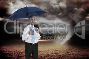 Composite image of happy businessman holding umbrella