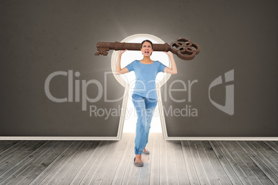 Composite image of annoyed brunette carrying large key