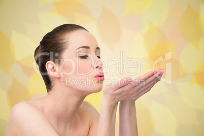 Composite image of beautiful brunette blowing over hands