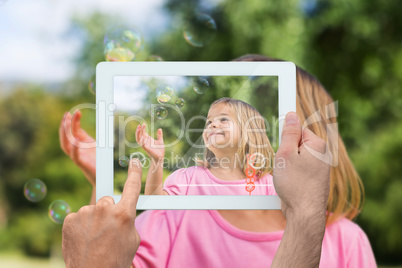 Composite image of hand holding tablet pc