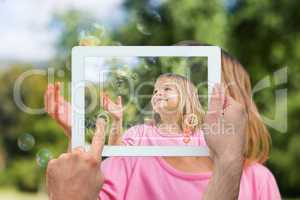 Composite image of hand holding tablet pc