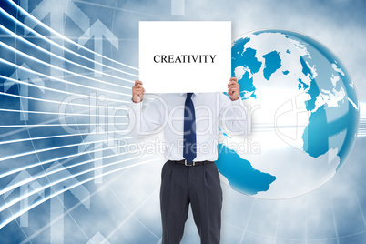 Businessman holding card saying creativity