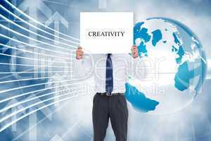 Businessman holding card saying creativity