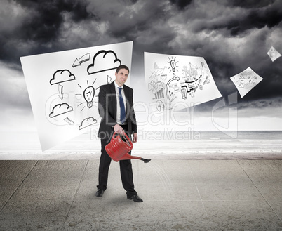 Composite image of businessman holding red watering can