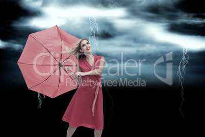 Composite image of elegant blonde holding umbrella