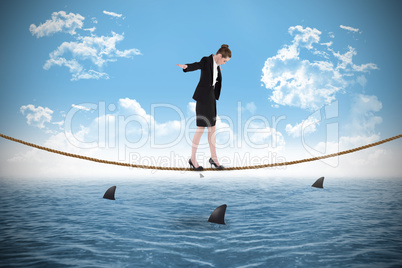 Composite image of businesswoman performing a balancing act