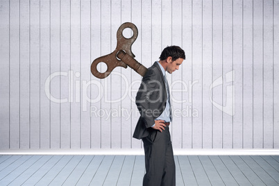 Composite image of wound up businessman with hands on hips