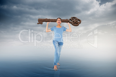 Composite image of annoyed brunette carrying large key