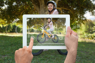 Composite image of hand holding tablet pc