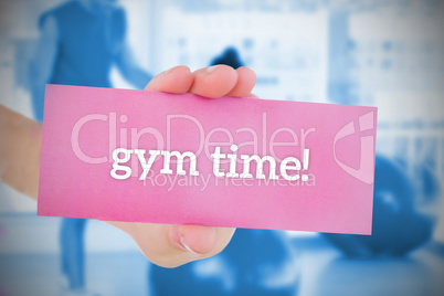 Woman holding pink card saying gym time