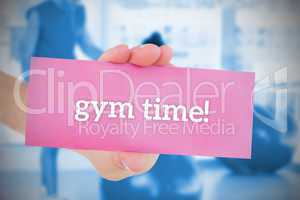 Woman holding pink card saying gym time
