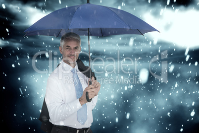 Composite image of businessman holding blue umbrella