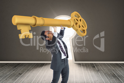 Composite image of stressed businessman carrying large key