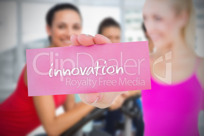 Fit blonde holding card saying innovation Fit blonde holding card saying innovation