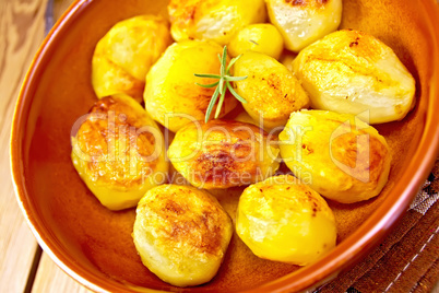 Potatoes fried in ceramic pan on board
