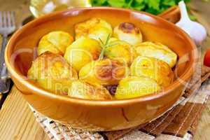 Potatoes fried in ceramic pan on napkin