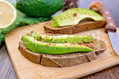 Sandwich with avocado and pepper on board