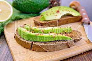 Sandwich with avocado and pepper on board