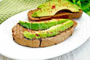 Sandwich with avocado and pepper on light board
