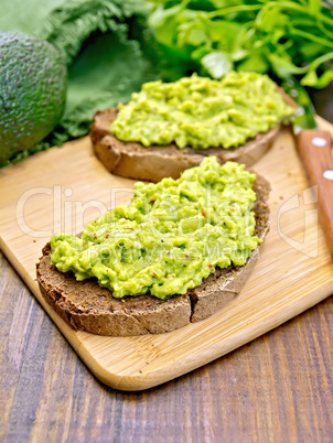 Sandwich with guacamole on dark board