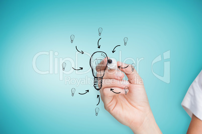 Composite image of businesswoman drawing light bulb