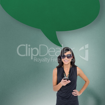 Composite image of happy brunette holding smartphone with speech
