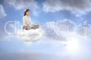 Composite image of businesswoman sitting in lotus pose