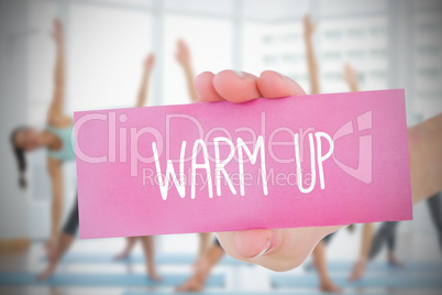 Woman holding pink card saying warm up