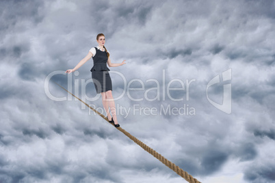 Composite image of businesswoman doing a balancing act