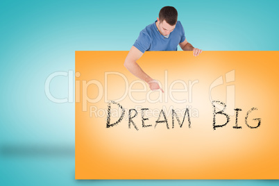 Handsome young man showing card with dream big