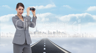 Composite image of businesswoman posing with binoculars