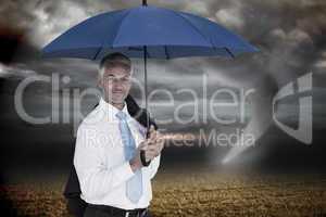 Composite image of businessman holding blue umbrella