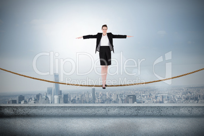 Composite image of businesswoman performing a balancing act